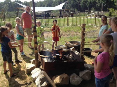 Kinderen bakken een lekker broodje boven kampvuur